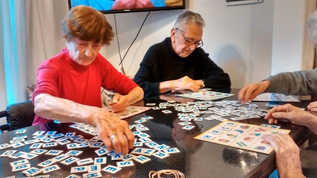 Adultos mayores jugando con letras en una actividad de LUL